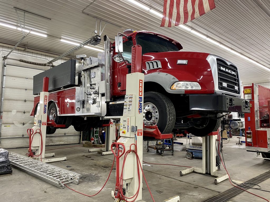 Fire truck on lift in service bay