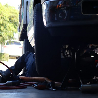 Technician inspecting the underside of a truck