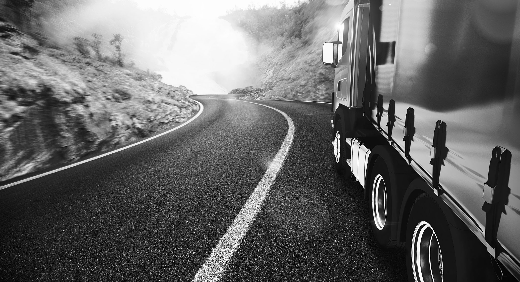 Semi truck driving down a mountain highway