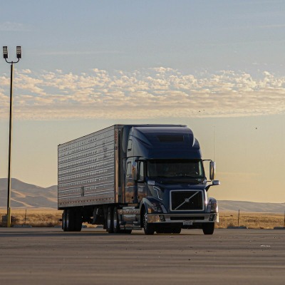 Semi truck with trailer parked at sunset
